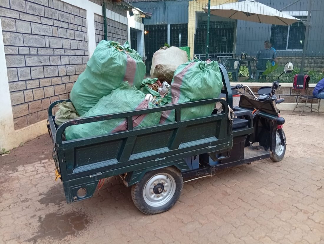 Electric cargo tricycle loaded with bagged recyclables collected around Bondo