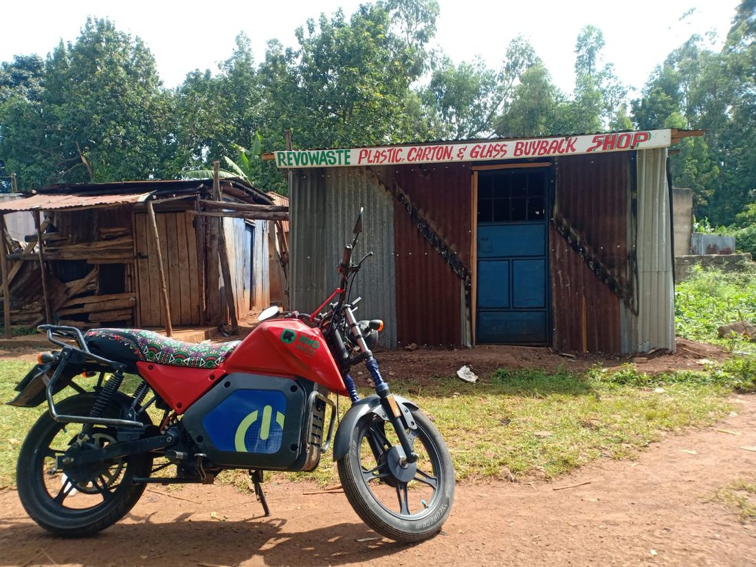 RevoWaste plastic, carton and glass buyback shop in Luanda with an electric delivery bike parked outside